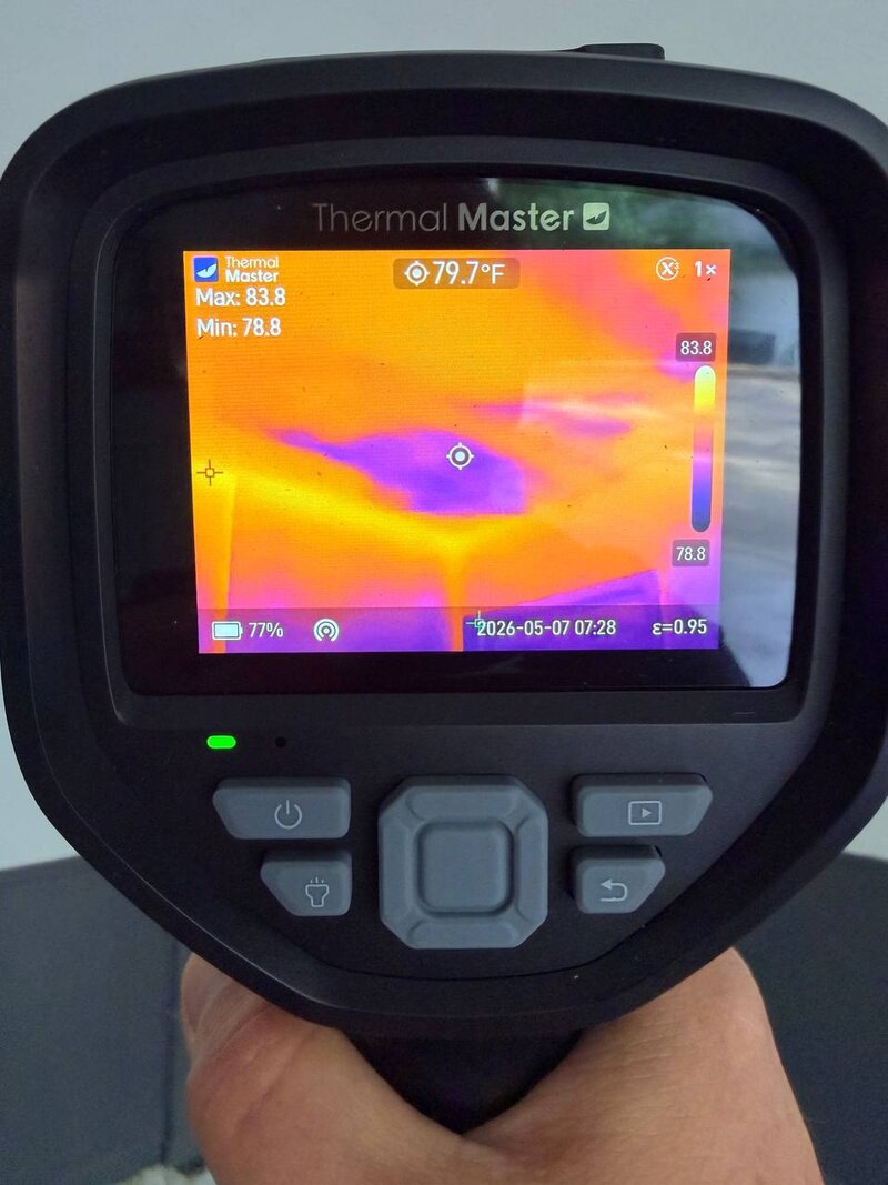 Thermal imaging camera showing a cold-pocket moisture signature in a ceiling cavity, used to locate hidden water damage